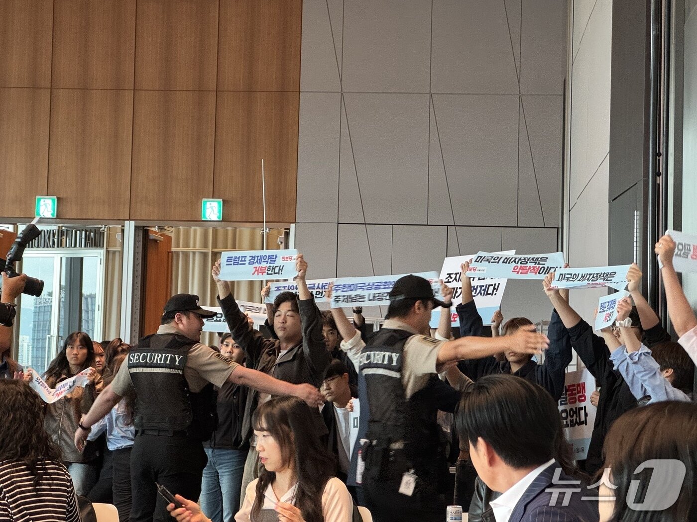 본문 이미지 - 진보당 서울시당 당원들이 29일 주한미국상공회의소(AMCHAM·암참)이 서울 영동프고 여의도 IFC에서 개최한 '미국 비자 세미나' 행사장에 들어와 피켓 시위를 진행하는 모습 2025.9.29/뉴스1 ⓒ News1 박종홍 기자