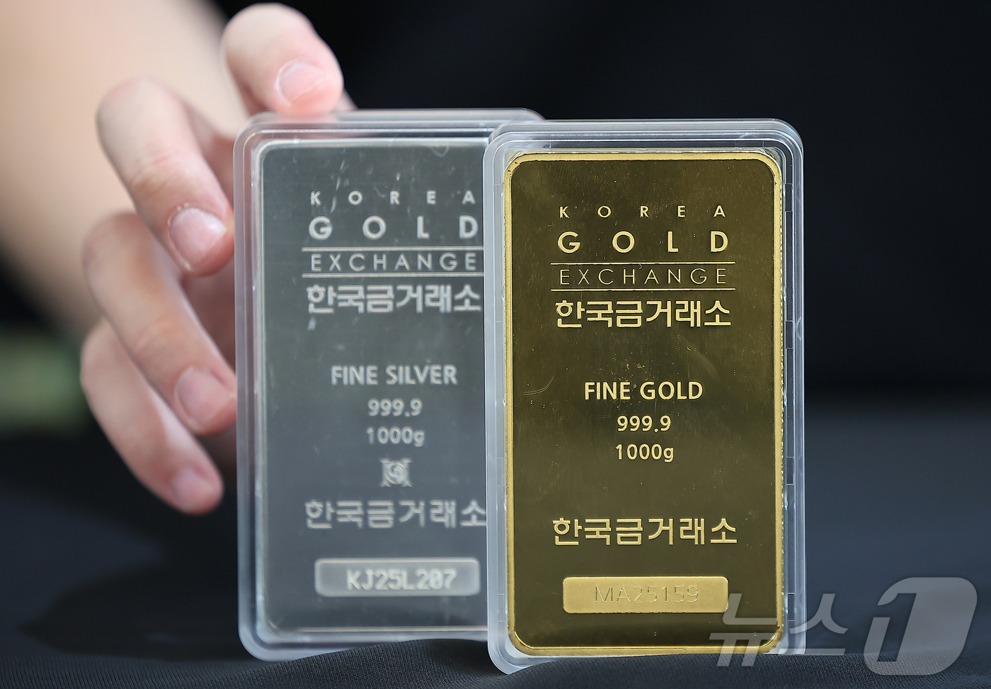 (서울=뉴스1) 김진환 기자 = 금과 은 가격이 급등세를 보이는 3일 서울 종로구 한국금거래소에서 관계자가 골드바와 실버바를 내보이고 있다.2일(현지시간) 뉴욕상품거래소에서 금 선 …