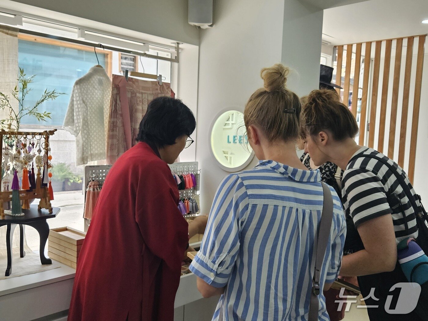 본문 이미지 - 1일 서울 종로구 인사동의 모던 한복 브랜드 '리슬'을 방문한 미국인 관광객들이 노리개 만들기 체험을 위해 부자재를 고르고 있다. 2025.09.01/뉴스1 ⓒ News1 유채연 기자