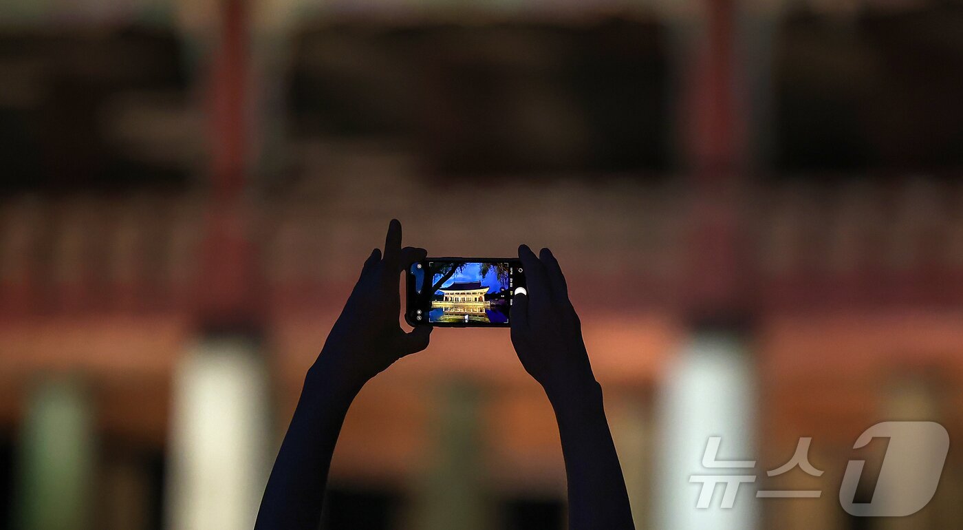 본문 이미지 - 경복궁 야간 관람이 시작된 3일 오후 서울 종로구 경복궁을 찾은 시민이 경회루를 스마트폰으로 촬영하고 있다.  2025.9.3/뉴스1 ⓒ News1 김진환 기자