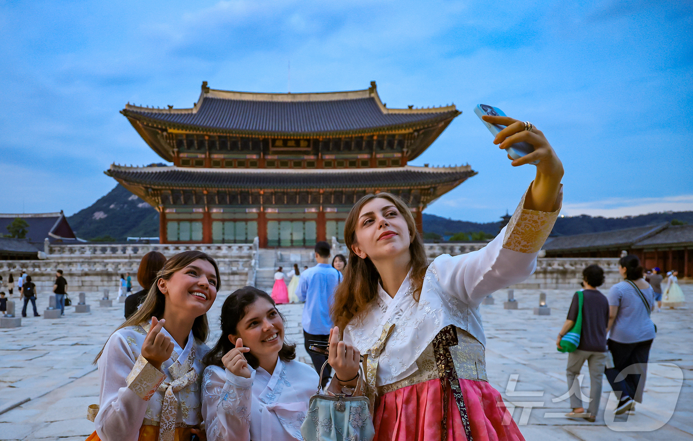 (서울=뉴스1) 김진환 기자 = 경복궁 야간 관람이 시작된 3일 오후 서울 종로구 경복궁을 찾은 외국인 관광객들이 근정전을 배경으로 셀카를 찍고 있다.국가유산청 궁능유적본부 경복궁 …