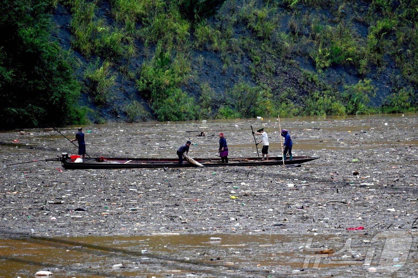 (라오까이 AFP=뉴스1) 권영미 기자 = 30일(현지시간) 베트남 라오까이성의 한 수력발전소 저수지에서 사람들이 오염된 수면 위에 떠 있는 장작을 수거하고 있다.2025.09.3 …