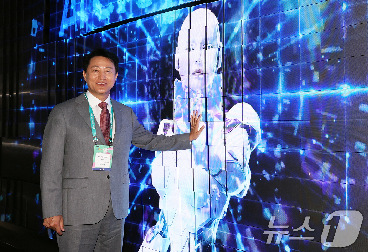 (서울=뉴스1) 오대일 기자 = 오세훈 서울시장이 30일 오후 서울 강남구 코엑스에서 열린 '스마트라이프위크(SLW) 2025'에서 키네틱 LED 터널에 표출되는 로봇손과 터치하고 …