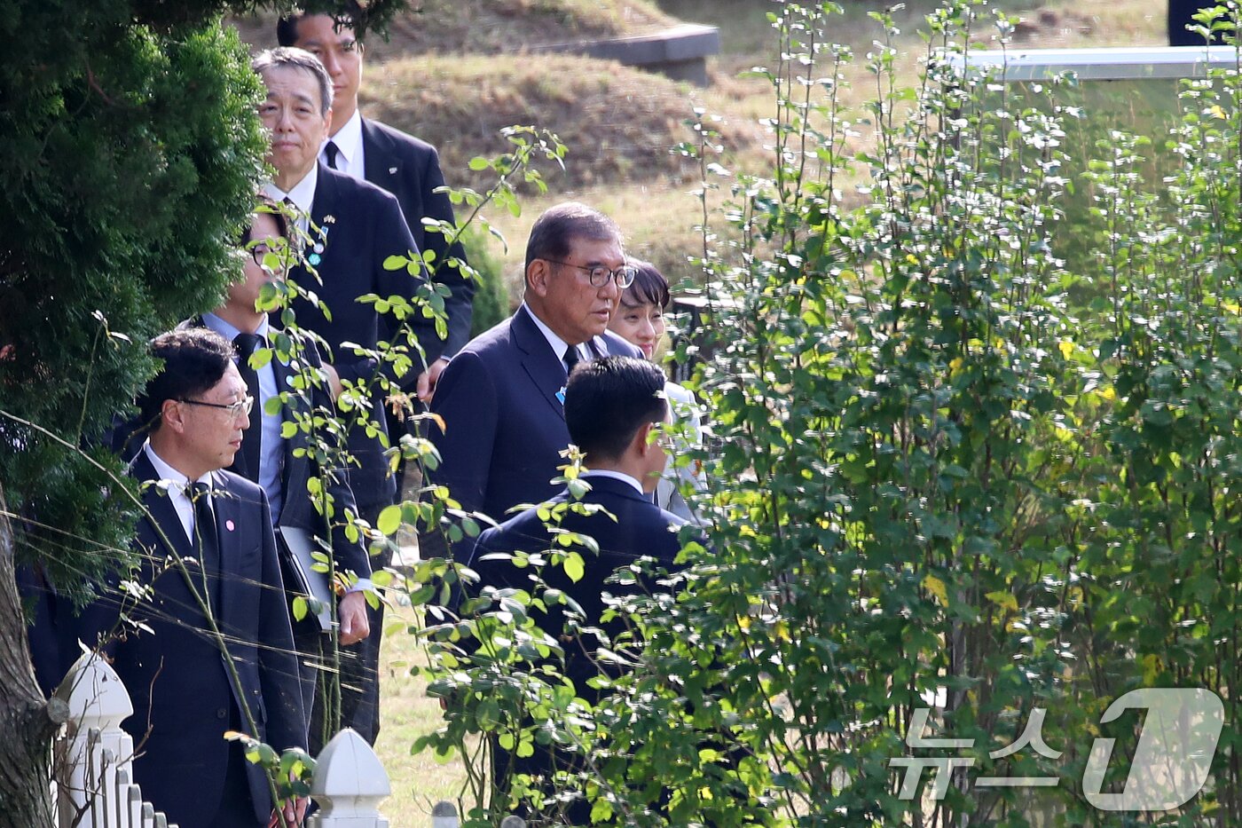 본문 이미지 - 이시바 시게루 일본 총리가 30일 오후 부산 금정구 시립공원묘지에서 2001년 도쿄 신오쿠보역 선로에 떨어진 일본인을 구하려다 목숨을 잃은 &#39;의인&#39; 이수현 씨 묘지를 참배하기 위해 이동하고 있다. 2025.9.30/뉴스1 ⓒ News1 윤일지 기자