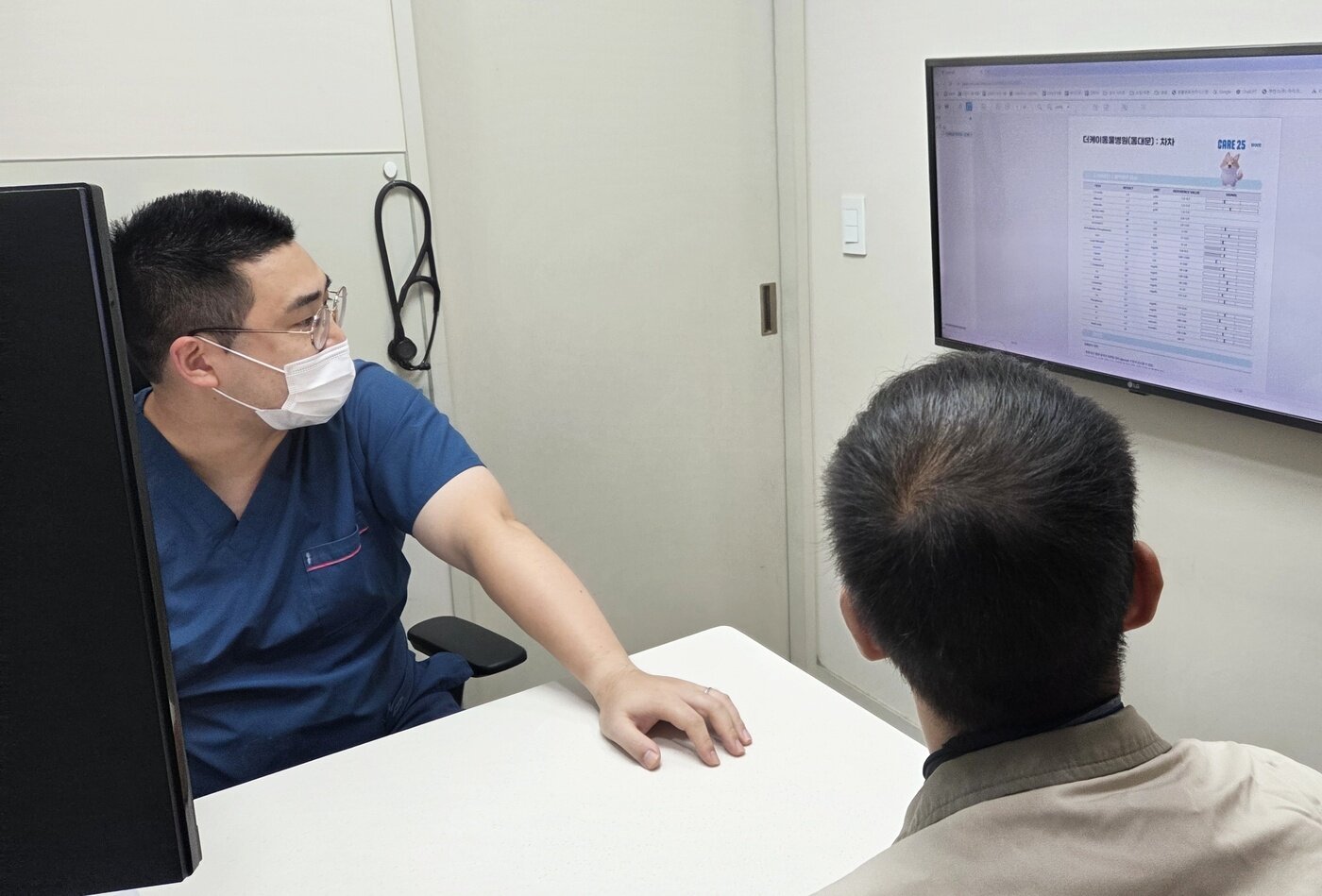 본문 이미지 - 국우경 더케이동물병원 원장이 케어25 건강검진 결과를 보며 보호자에게 설명하고 있다. ⓒ 뉴스1 한송아 기자