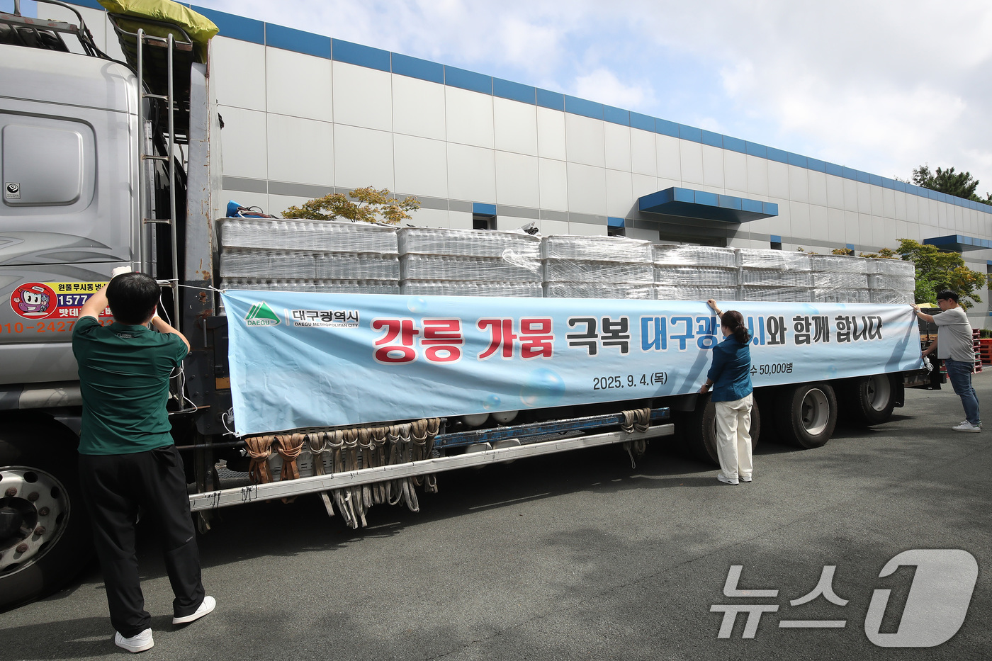 (대구=뉴스1) 공정식 기자 = 4일 오전 대구 수성구 노변동 대구시상수도사업본부 고산정수사업소에서 사업소 관계자들이 강릉 가뭄 극복을 위한 청라수 지원 현수막을 운반 차량에 설치 …
