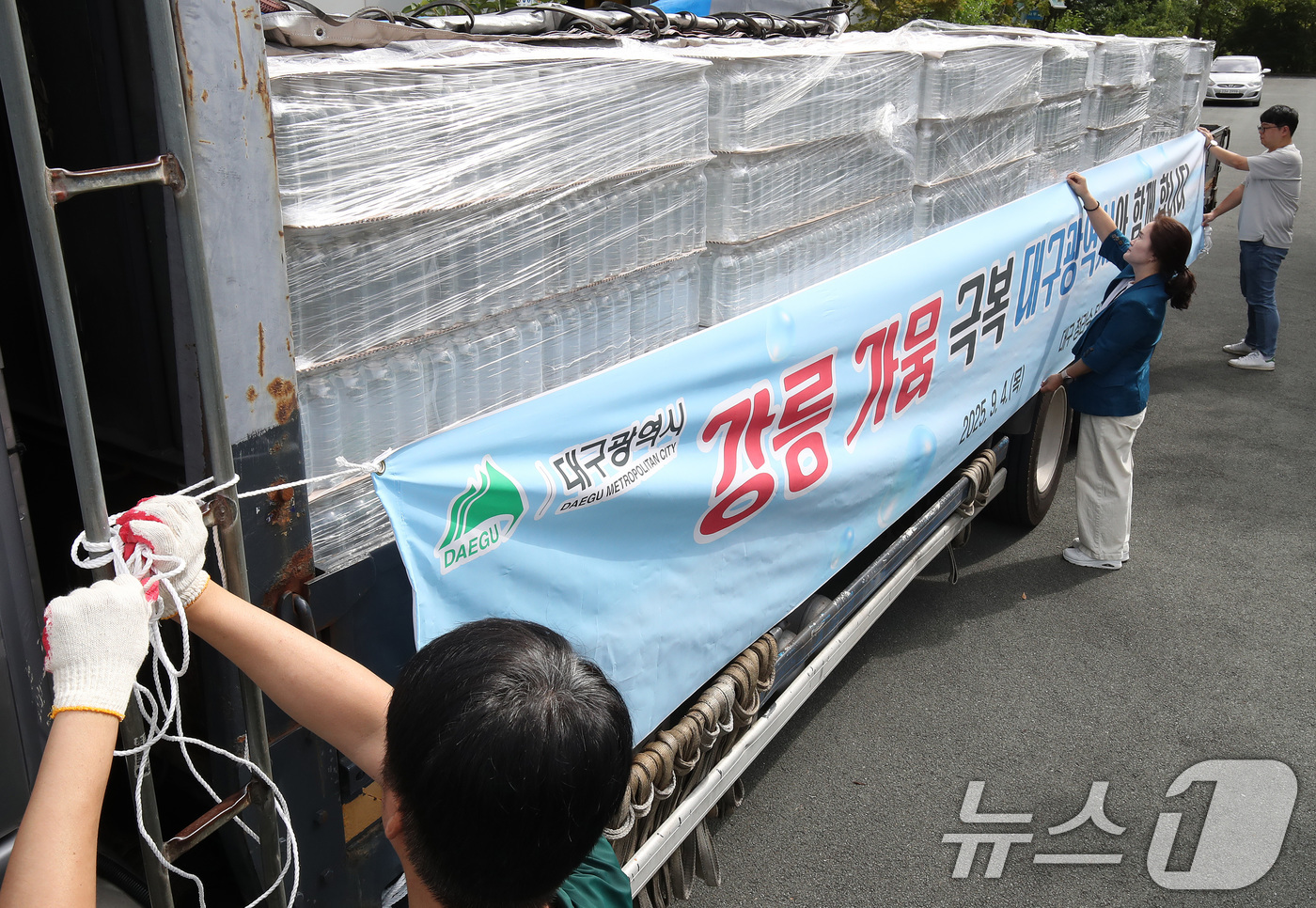 (대구=뉴스1) 공정식 기자 = 4일 오전 대구 수성구 노변동 대구시상수도사업본부 고산정수사업소에서 사업소 관계자들이 강릉 가뭄 극복을 위한 청라수 지원 현수막을 운반 차량에 설치 …