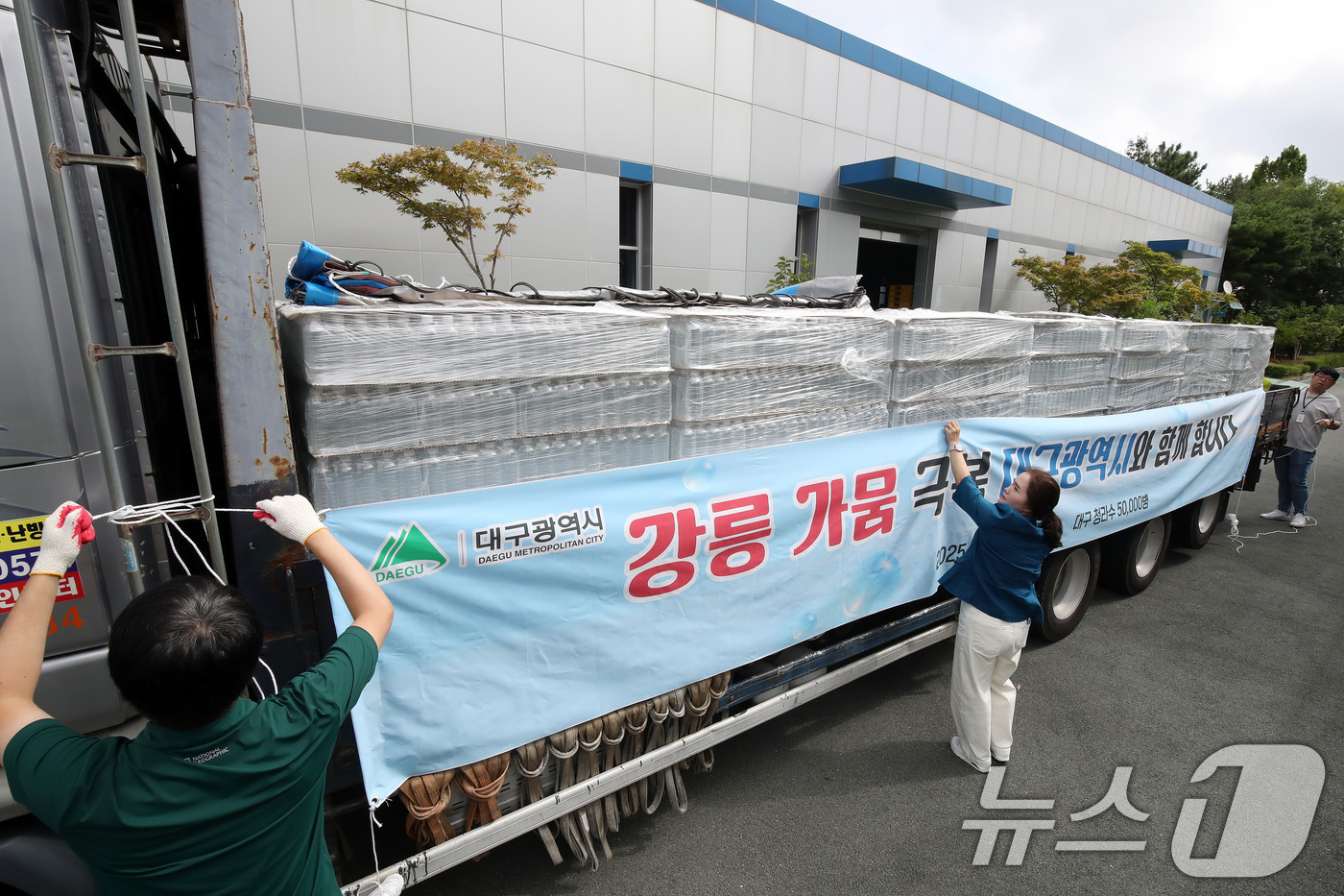 (대구=뉴스1) 공정식 기자 = 4일 오전 대구 수성구 노변동 대구시상수도사업본부 고산정수사업소에서 사업소 관계자들이 강릉 가뭄 극복을 위한 청라수 지원 현수막을 운반 차량에 설치 …