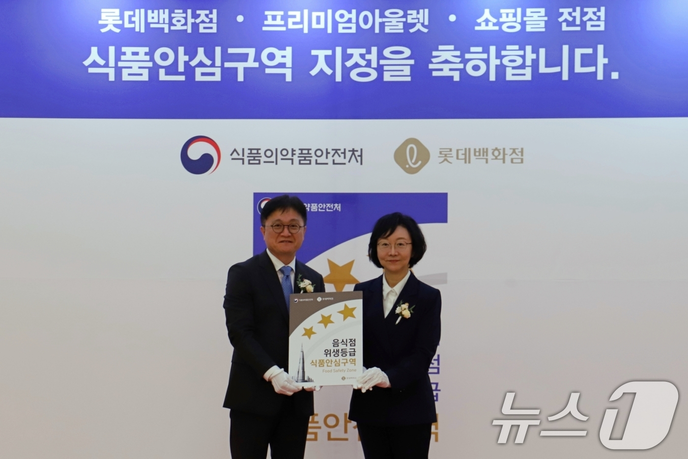 (서울=뉴스1) = 롯데백화점이 4일 서울 송파구 잠실 롯데월드몰 1층 아트리움에서 식품의약품안전처와 함께 '식품안심구역' 지정식을 열었다.오유경 식약처장이 김진엽 롯데백화점 오퍼 …