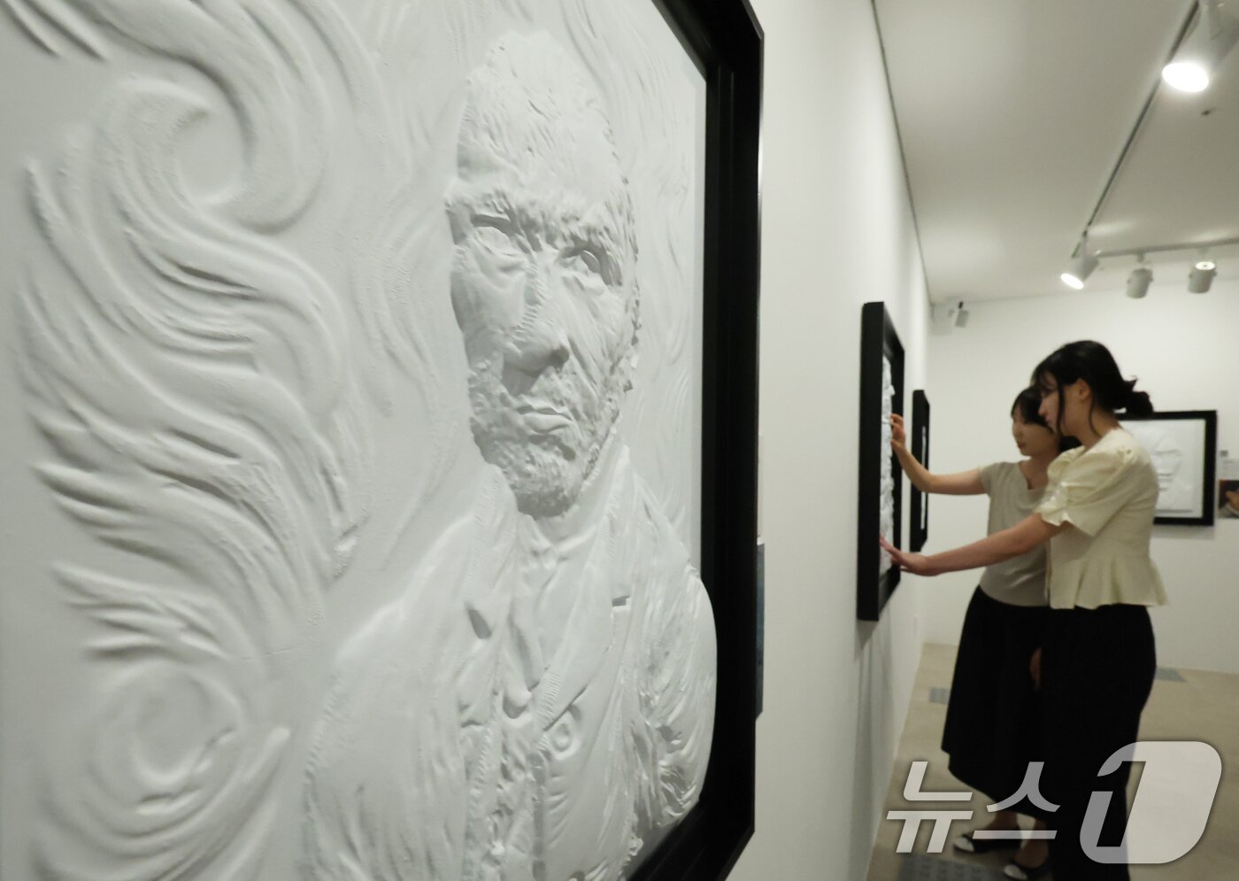 본문 이미지 - 4일 서울 종로구 한국장애인문화예술원 이음갤러리에서 열린 시각장애인을 위한 어두운 미술관 '감각; 예술을 만나는 또 다른 방법' 전시에서 관계자들이 색채를 빼고 3D로 구현된 명화를 만져보고 있다. 2025.9.4/뉴스1 ⓒ News1 장수영 기자