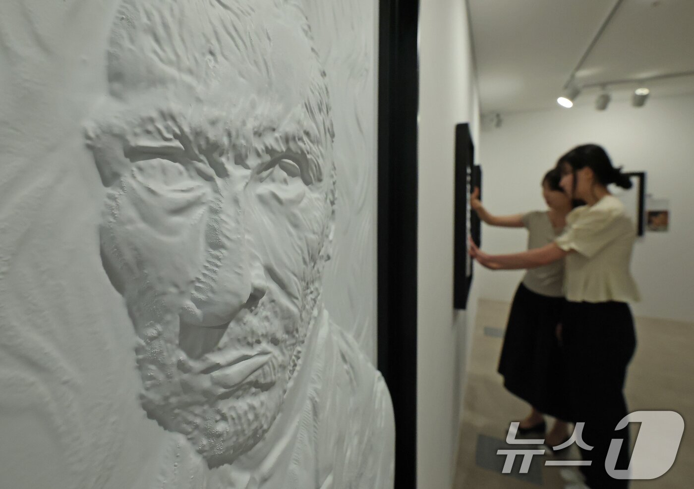 본문 이미지 - 4일 서울 종로구 한국장애인문화예술원 이음갤러리에서 열린 시각장애인을 위한 어두운 미술관 '감각; 예술을 만나는 또 다른 방법' 전시에서 관계자들이 색채를 빼고 3D로 구현된 명화를 만져보고 있다. 2025.9.4/뉴스1 ⓒ News1 장수영 기자