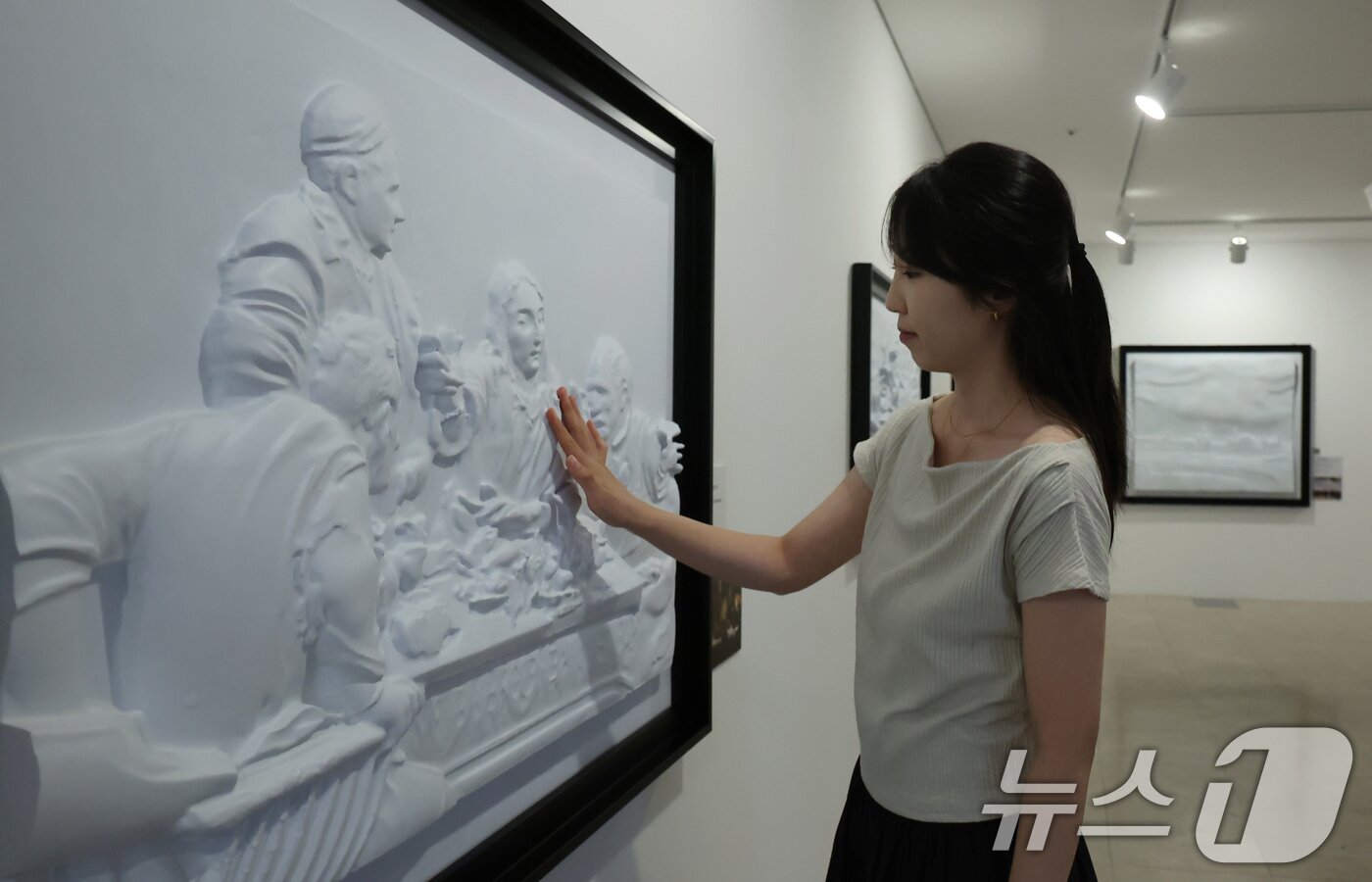 본문 이미지 - 4일 서울 종로구 한국장애인문화예술원 이음갤러리에서 열린 시각장애인을 위한 어두운 미술관 '감각; 예술을 만나는 또 다른 방법' 전시에서 관계자들이 색채를 빼고 3D로 구현된 명화를 만져보고 있다. 2025.9.4/뉴스1 ⓒ News1 장수영 기자