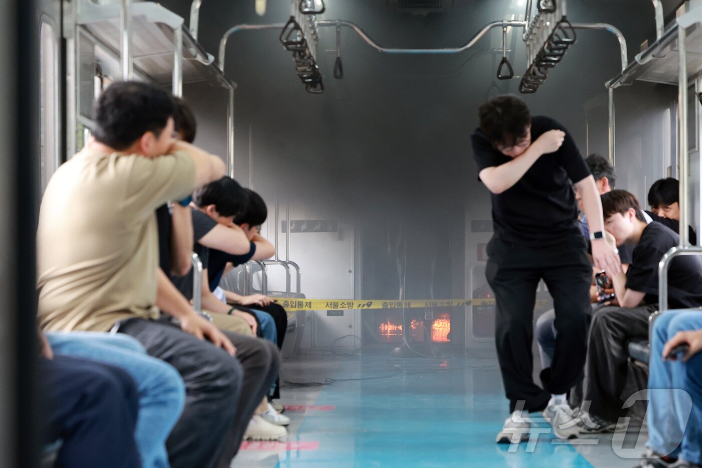 본문 이미지 - 4일 오후 경기도 고양시 지축차량기지에서 전동차 화재 시연이 열린 가운데 불이 난 전동차 객실에서 승객을 가정한 서울교통공사 직원들이 대피하고 있다. &#40;공동취재&#41; 2025.9.4/뉴스1 ⓒ News1 김진환 기자