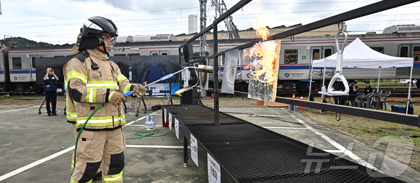 본문 이미지 - 4일 오후 경기 고양시 지축차량기지에서 열린 5호선 열차 방화관련 화재안정성 및 비상대응 검증을 위한 전동차 화재안전 시연회에서 소방 관계자가 전동차 내장재 6종에 대한 방염 성능 테스트를 하고 있다. &#40;공동취재&#41; 2025.9.4/뉴스1 ⓒ News1 김진환 기자