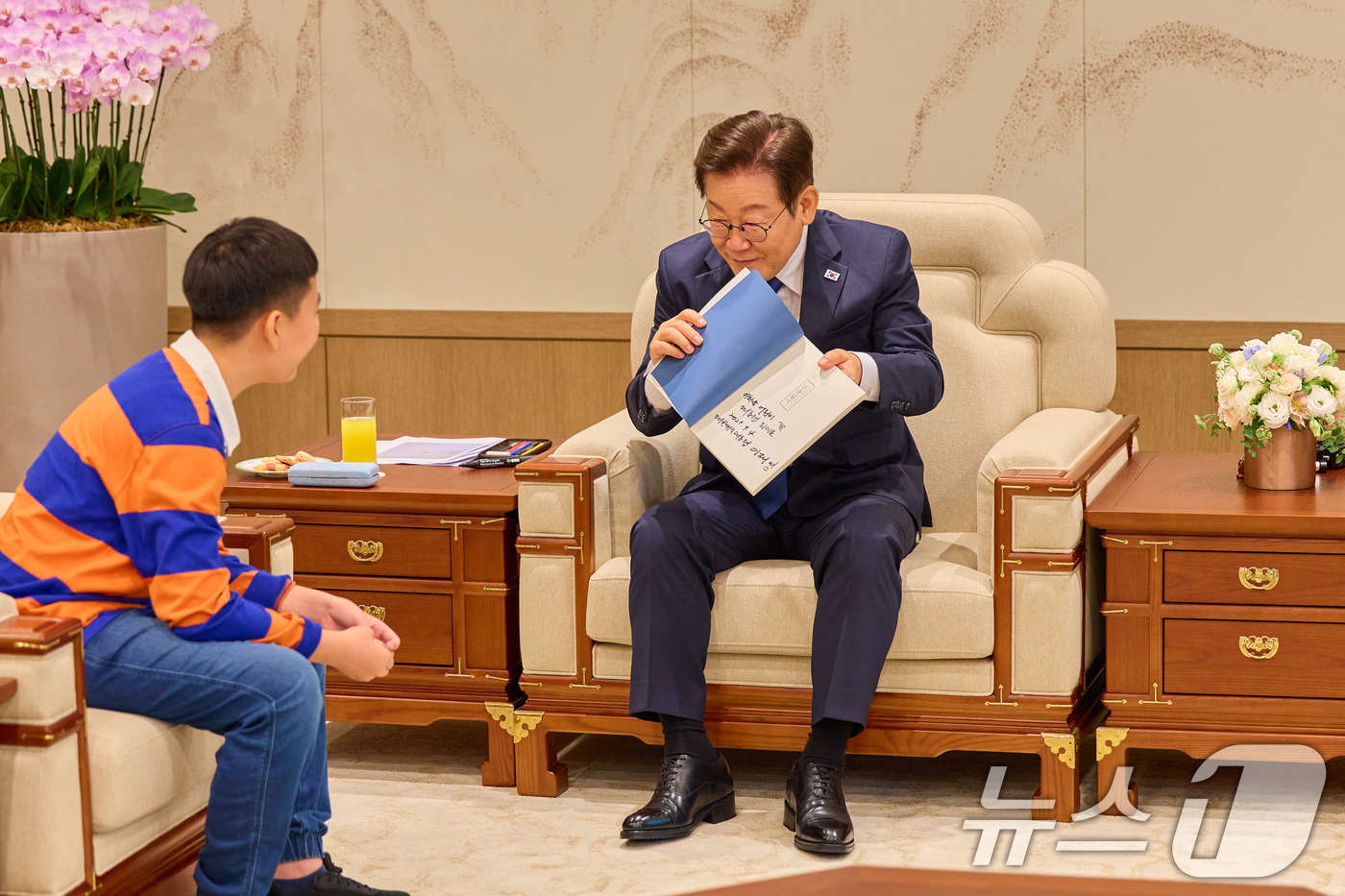 (서울=뉴스1) 허경 기자 = 이재명 대통령이 4일 서울 용산 대통령실 청사에서 열린 어린이 초청 행사에서 참석자에게 사인이 담긴 책을 선물하고 있다. (대통령실 제공. 재판매 및 …