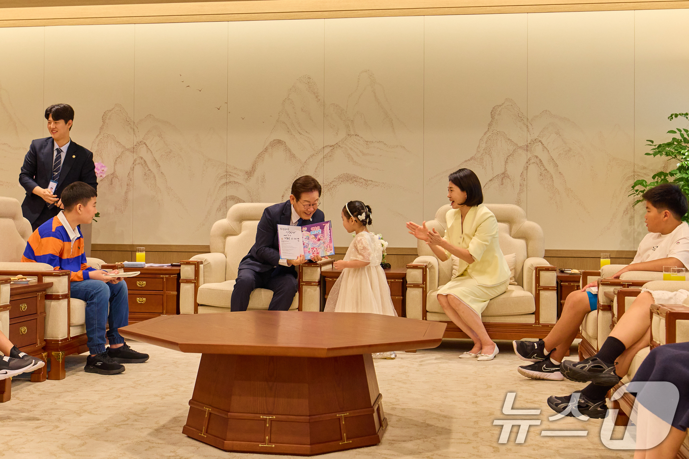 (서울=뉴스1) 허경 기자 = 이재명 대통령이 4일 서울 용산 대통령실 청사에서 열린 어린이 초청 행사에서 참석자에게 사인이 담긴 책을 선물하고 있다. (대통령실 제공. 재판매 및 …