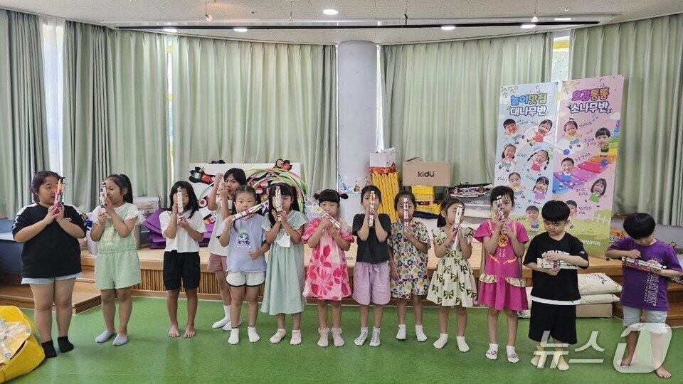 본문 이미지 - 유치원생들이 캄보디야 전통 악기 &#39;크엔&#39;을 만들어보는 체험 활동을 하고 있다.  