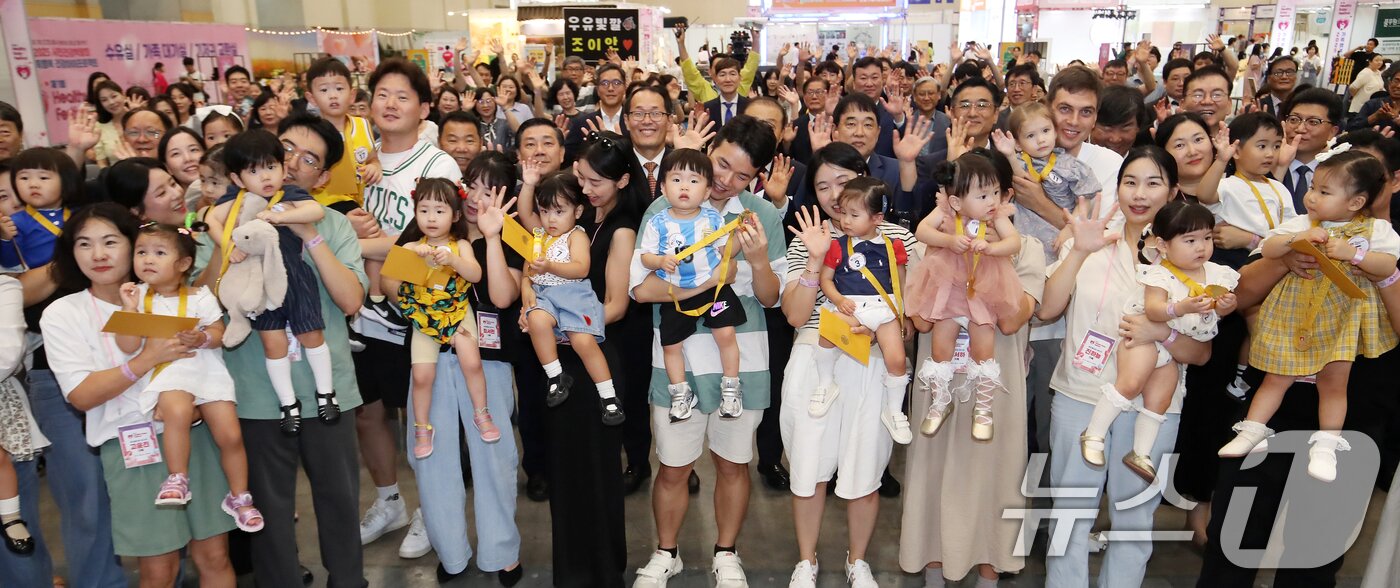 본문 이미지 - 5일 부산 해운대구 벡스코 제1전시장에서 열린 '제1회 헬시·큐티 베이비 페스티벌'에서 큐티 베이비 부문에 참가한 아기와 부모들이 기념촬영을 하고 있다.  2025.9.5/뉴스1 ⓒ News1 윤일지 기자