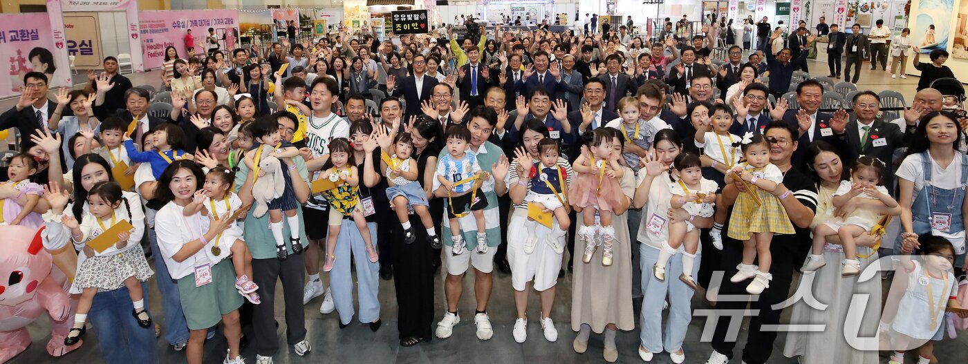 본문 이미지 - 5일 부산 해운대구 벡스코 제1전시장에서 열린 '제1회 헬시·큐티 베이비 페스티벌'에서 큐티 베이비 부문에 참가한 아기와 부모들이 기념촬영을 하고 있다.  2025.9.5/뉴스1 ⓒ News1 윤일지 기자