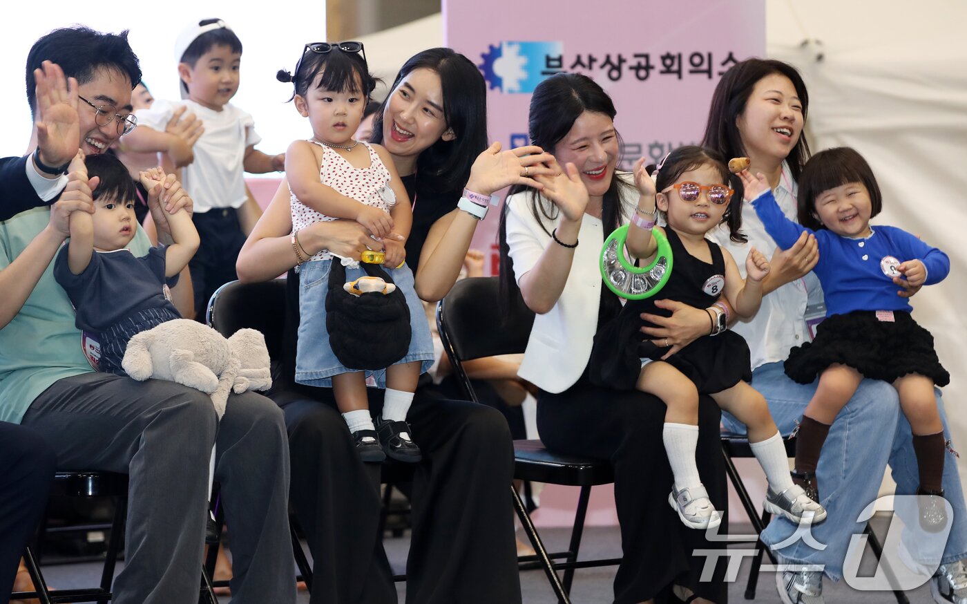 본문 이미지 - 5일 부산 해운대구 벡스코 제1전시장에서 열린 '제1회 헬시·큐티 베이비 페스티벌'에서 큐티 베이비 부문에 참가한 아기들이 부모와 함께 무대에 올라 관객석을 바라보고 있다.  2025.9.5/뉴스1 ⓒ News1 윤일지 기자