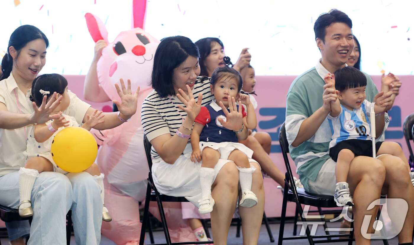 본문 이미지 - 5일 부산 해운대구 벡스코 제1전시장에서 열린 '제1회 헬시·큐티 베이비 페스티벌'에서 큐티 베이비 부문에 참가한 아기들이 부모와 함께 무대에 올라 관객석을 바라보고 있다.  2025.9.5/뉴스1 ⓒ News1 윤일지 기자