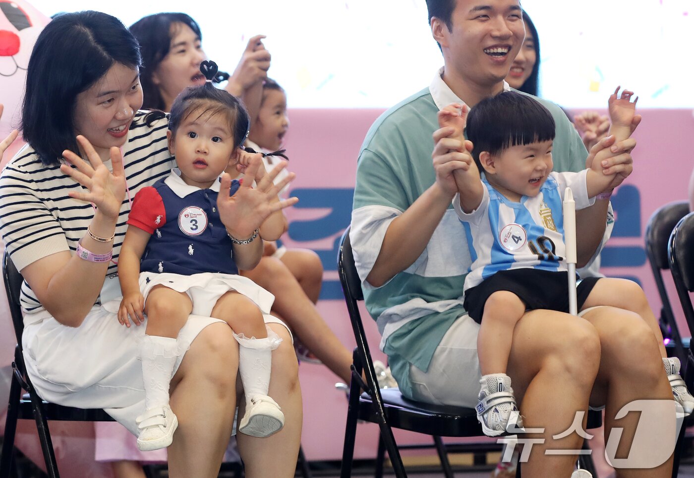 본문 이미지 - 5일 부산 해운대구 벡스코 제1전시장에서 열린 '제1회 헬시·큐티 베이비 페스티벌'에서 큐티 베이비 부문에 참가한 아기들이 부모와 함께 무대에 올라 관객석을 바라보고 있다.  2025.9.5/뉴스1 ⓒ News1 윤일지 기자