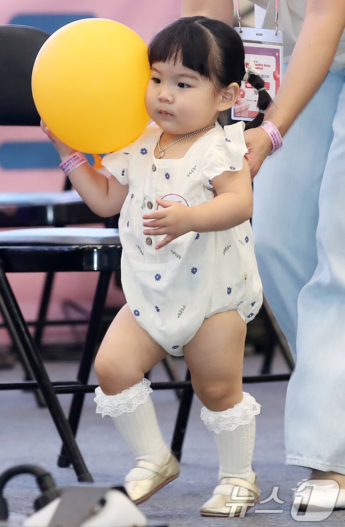 본문 이미지 - 5일 부산 해운대구 벡스코 제1전시장에서 열린 '제1회 헬시·큐티 베이비 페스티벌'에서 큐티 베이비 부문에 참가한 아기가 부모와 함께 무대에 오르고 있다.  2025.9.5/뉴스1 ⓒ News1 윤일지 기자