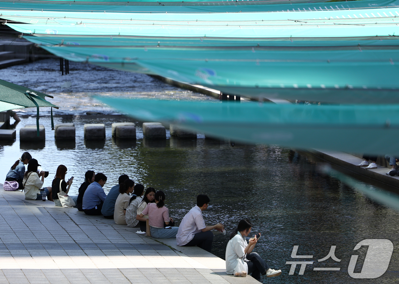 (서울=뉴스1) 김민지 기자 = 서울 낮 기온이 30도 이상 오르며 푹푹 찌는 무더위가 이어진 5일 오후 서울 청계천에 마련된 그늘막 아래에서 시민들이 휴식을 취하고 있다. 202 …