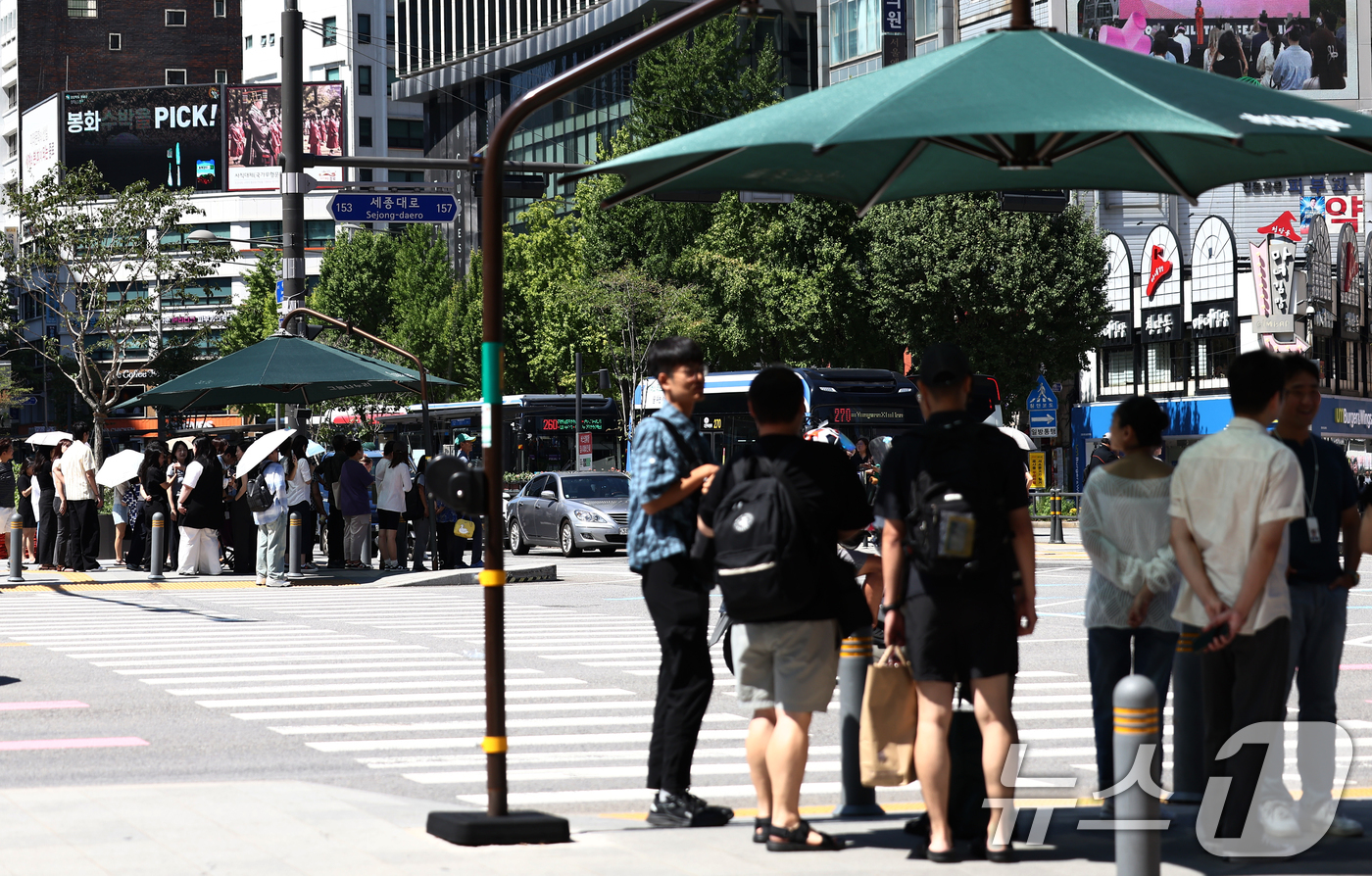 (서울=뉴스1) 김민지 기자 = 서울 낮 기온이 30도 이상 오르며 푹푹 찌는 무더위가 이어진 5일 오후 서울 종로구 세종대로에서 시민들이 그늘 아래에서 햇빛을 피하고 있다. 20 …