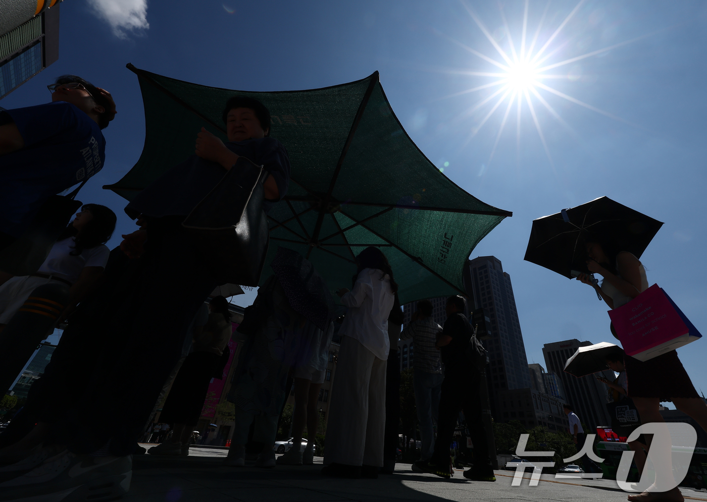 (서울=뉴스1) 김민지 기자 = 서울 낮 기온이 30도 이상 오르며 푹푹 찌는 무더위가 이어진 5일 오후 서울 종로구 세종대로에 시민들이 그늘막에서 햇볕을 피하고 있다. 2025. …