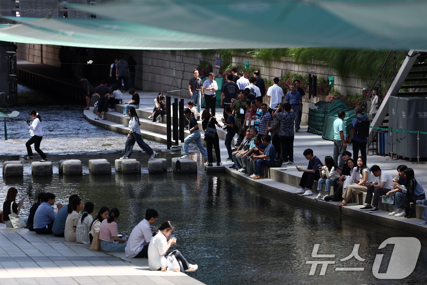 (서울=뉴스1) 김민지 기자 = 서울 낮 기온이 30도 이상 오르며 푹푹 찌는 무더위가 이어진 5일 오후 서울 청계천에 마련된 그늘막 아래에서 시민들이 휴식을 취하고 있다. 202 …