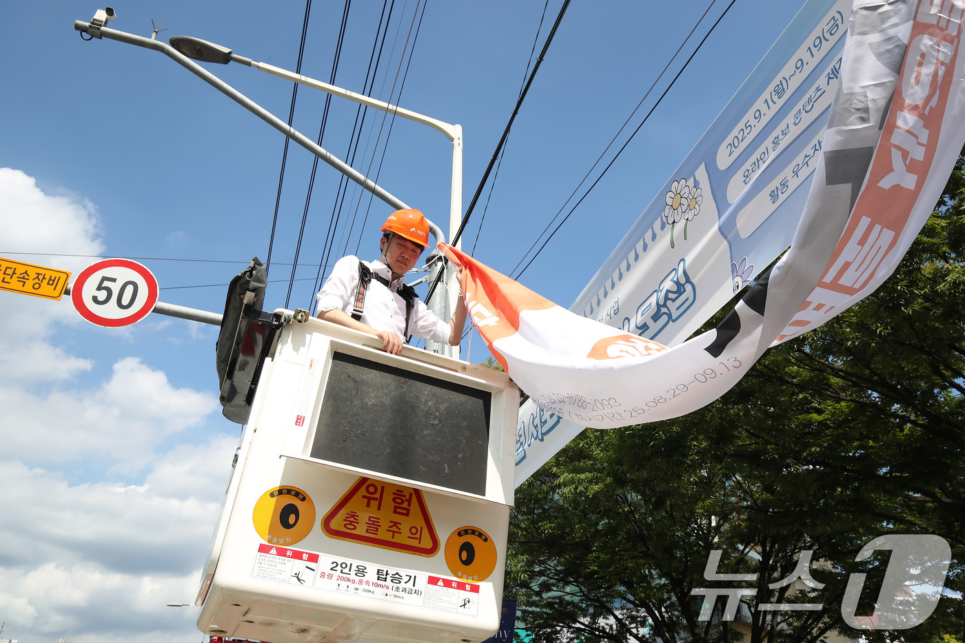 (대구=뉴스1) 공정식 기자 = 이준석 개혁신당 대표가 5일 오후 대구 북구 경북대학교 북문 앞에서 직접 고소작업차에 올라 당원모집 현수막을 설치하고 있다. 2025.9.5/뉴스1 …