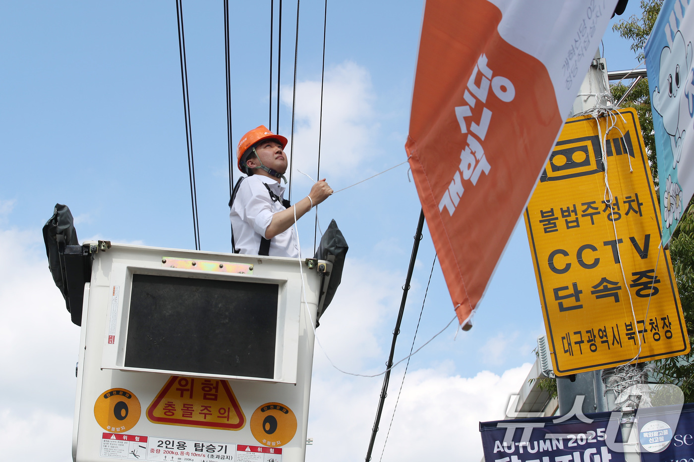 (대구=뉴스1) 공정식 기자 = 이준석 개혁신당 대표가 5일 오후 대구 북구 경북대학교 북문 앞에서 직접 고소작업차에 올라 당원모집 현수막을 설치하고 있다. 2025.9.5/뉴스1 …