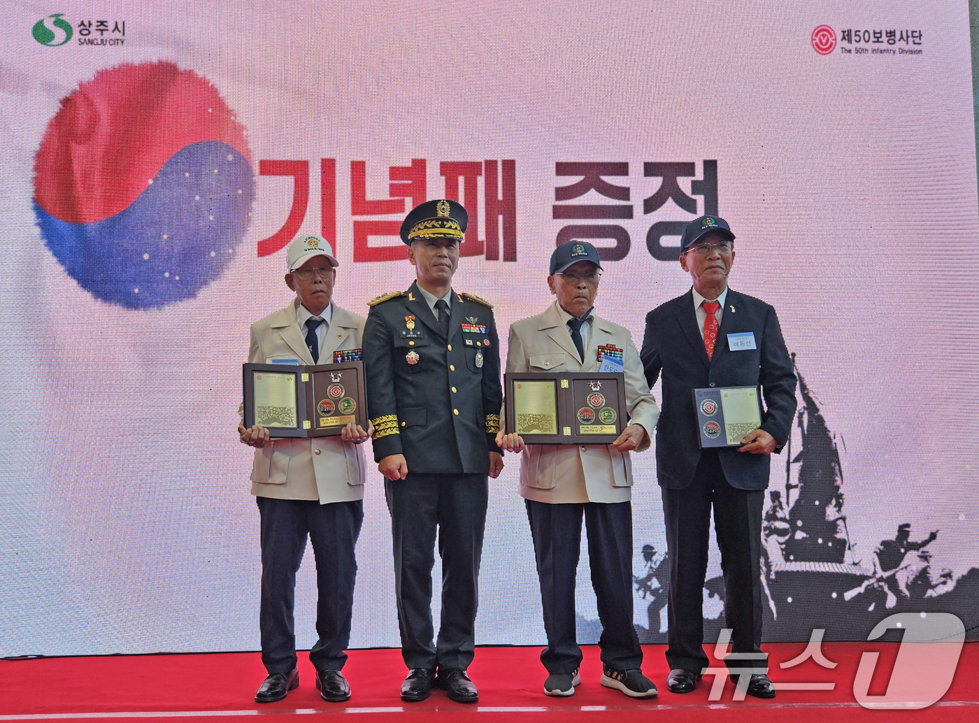 (상주=뉴스1) 최창호 기자 = 정유수 육군 50사단장이 6일 경북 상주시 상주화령장전투전승기념관에서 열린 6.25전쟁 전승기념행사에서 참전용사들에게 기념패를 수여한 후 기념촬영을 …