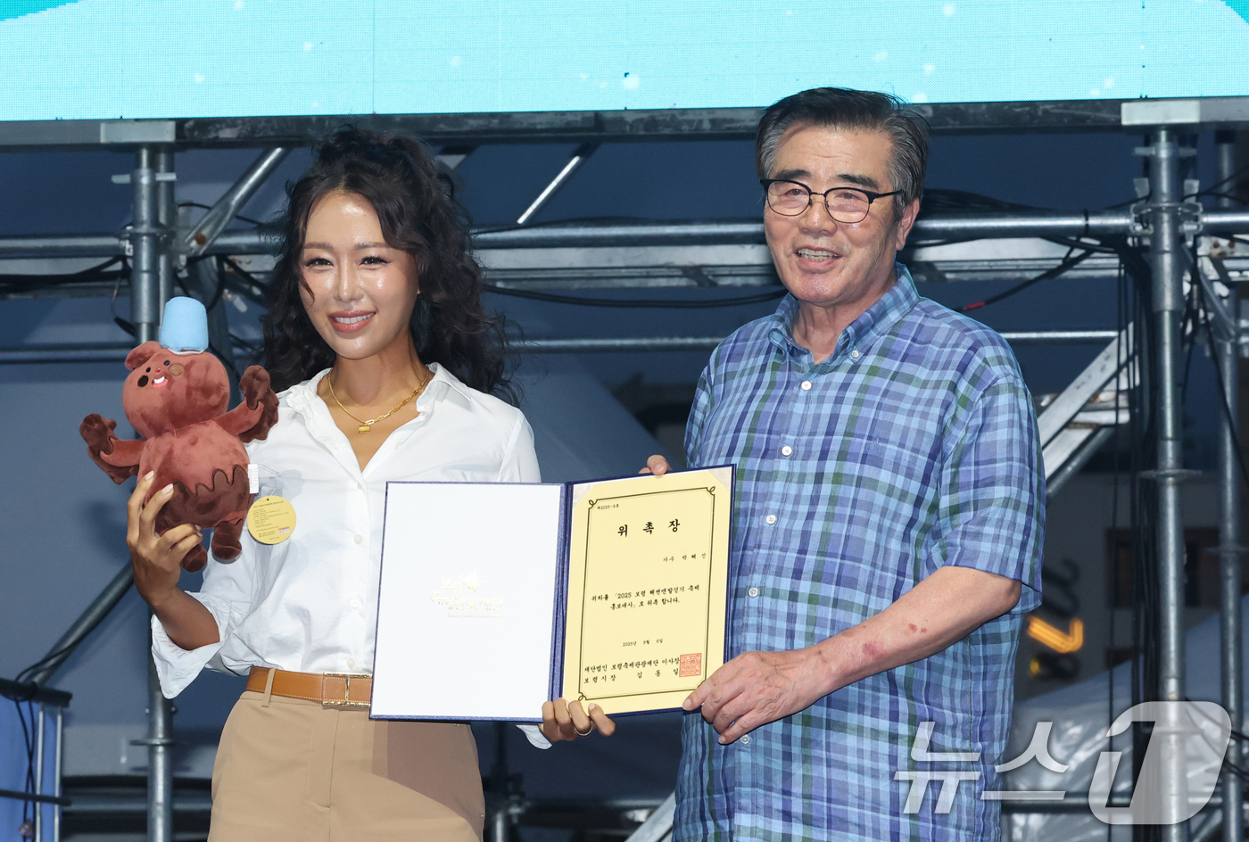 (보령=뉴스1) 김기태 기자 = 6일 충남 보령 대천해수욕장에서 열린 '보령 해변 맨발 걷기 축제' 개막식에서 김동일 보령시장이 박신혜 홍보대사에게 위촉장을 전달하고 있다. 202 …