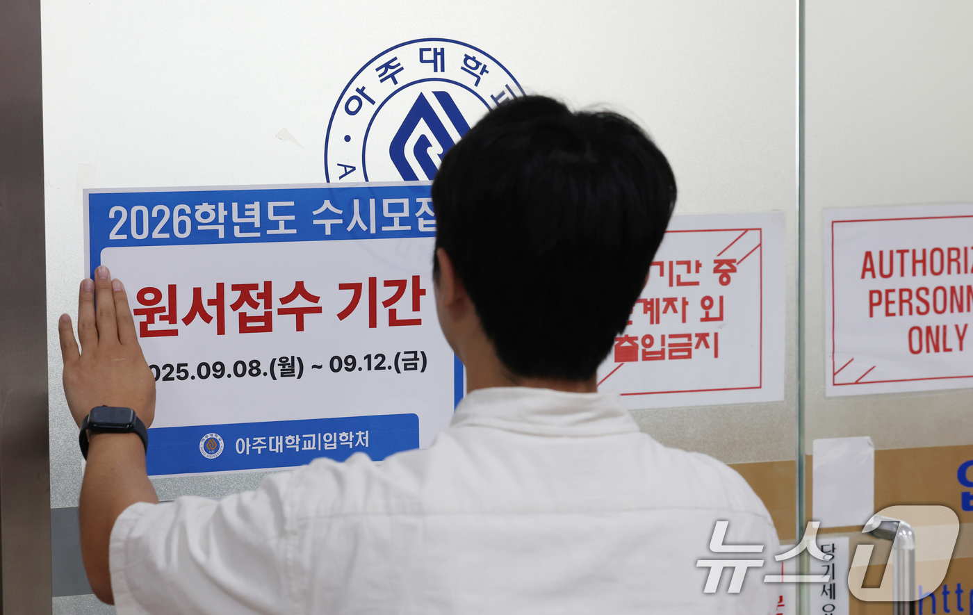 (수원=뉴스1) 김영운 기자 = 2026학년도 수시모집 원서 접수가 시작된 8일 경기 수원시 영통구 아주대학교 입학처 앞에 관계자가 2026학년도 수시모집을 알리는 게시물을 부착하 …