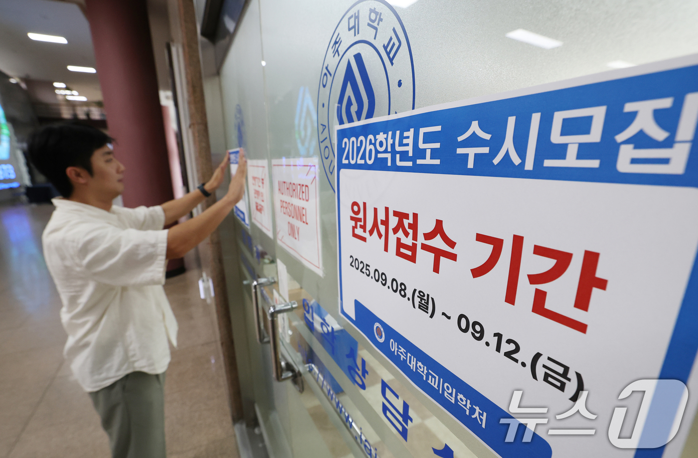 (수원=뉴스1) 김영운 기자 = 2026학년도 수시모집 원서 접수가 시작된 8일 경기 수원시 영통구 아주대학교 입학처 앞에 관계자가 2026학년도 수시모집을 알리는 게시물을 부착하 …