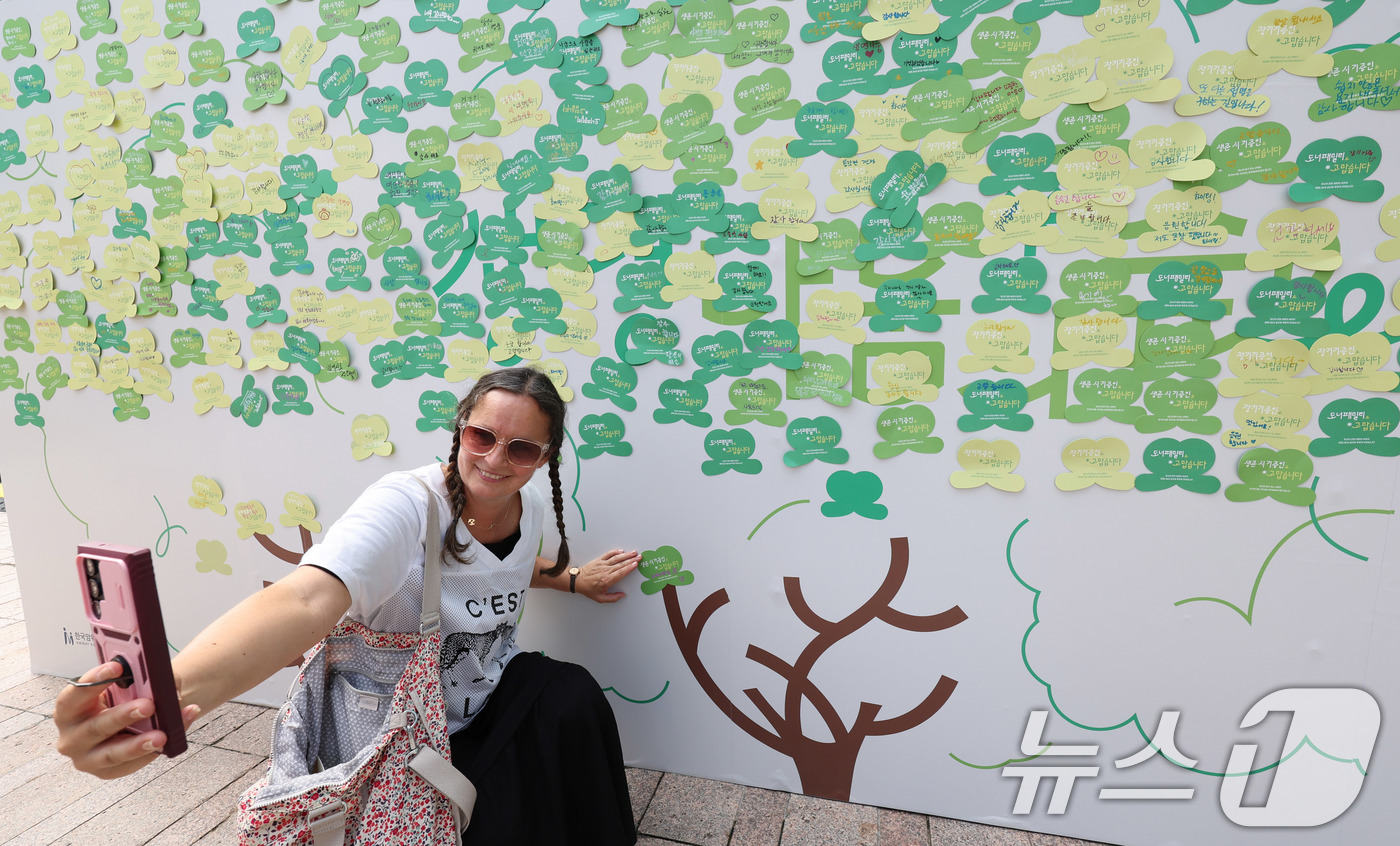 (서울=뉴스1) 박지혜 기자 = 8일 서울광장에서 열린 2025 서울시 장기기증의 날 행사를 찾은 한 외국인이 희망의 메시지를 붙인 뒤 기념 촬영을 하고 있다.사랑의장기기증운동본부 …