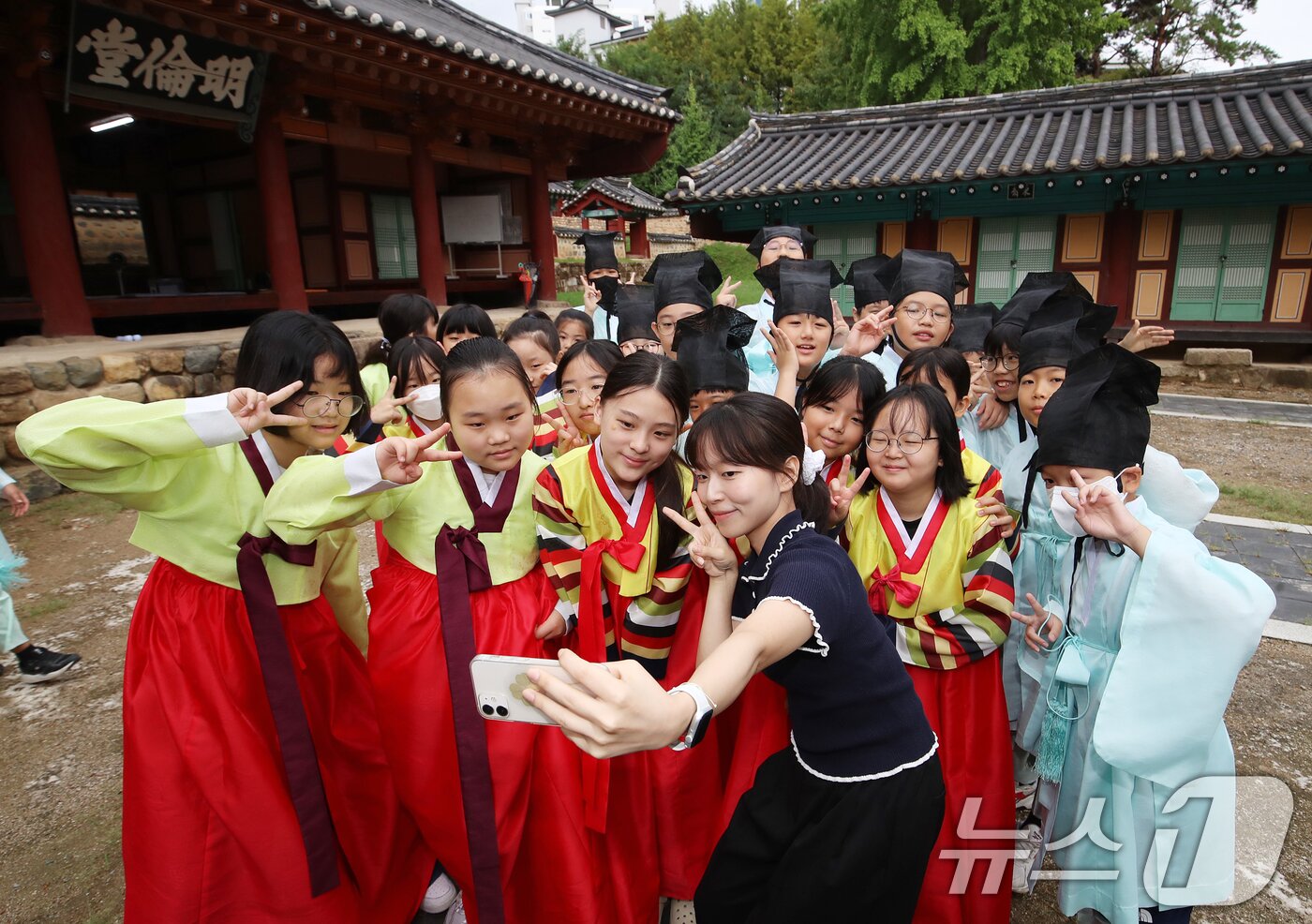 본문 이미지 - 추석 연휴를 3주 가량 앞둔 9일 오전 부산 동래구 동래향교에서 열린 '동래향교 인성·예절 체험교실'에서 명륜초등학교 5학년 학생들이 선생님과 셀카를 찍고 있다. 2025.9.9/뉴스1 ⓒ News1 윤일지 기자