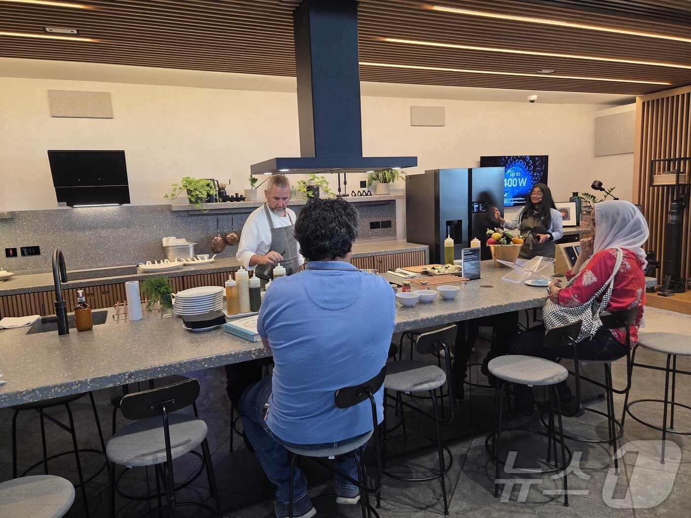 본문 이미지 - 영국 런던 킹스크로스 지역에 있는 삼성전자의 브랜드 쇼케이스 '삼성 킹스크로스(KX)' 안에서 셰프가 고객들 앞에서 삼성전자 주방가전을 이용해 요리하고 있다. 2025.9.8/뉴스1 ⓒ News1 박주평 기자