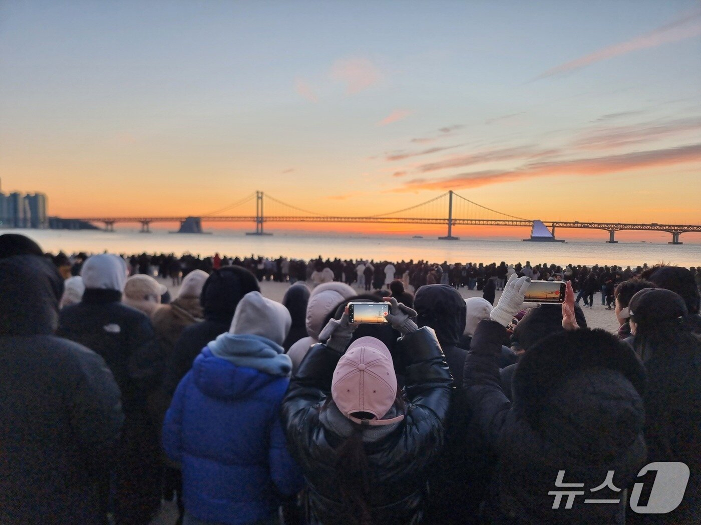 본문 이미지 - 2026년 병오년의 시작인 1일 오전 부산 광안리해수욕장을 찾은 시민들이 떠오르는 첫 해를 보며 스마트폰을 들고 사진을 찍고 있다. 2026.1.1/뉴스1 ⓒ News1 임순택 기자