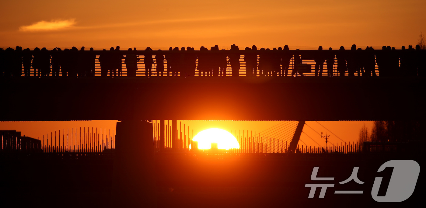 (대구=뉴스1) 공정식 기자 = 1일 오전 대구 동구 금호강 아양기찻길을 찾은 시민들이 2026년 희망찬 새해 첫 일출을 맞이하고 있다. 2026.1.1/뉴스1