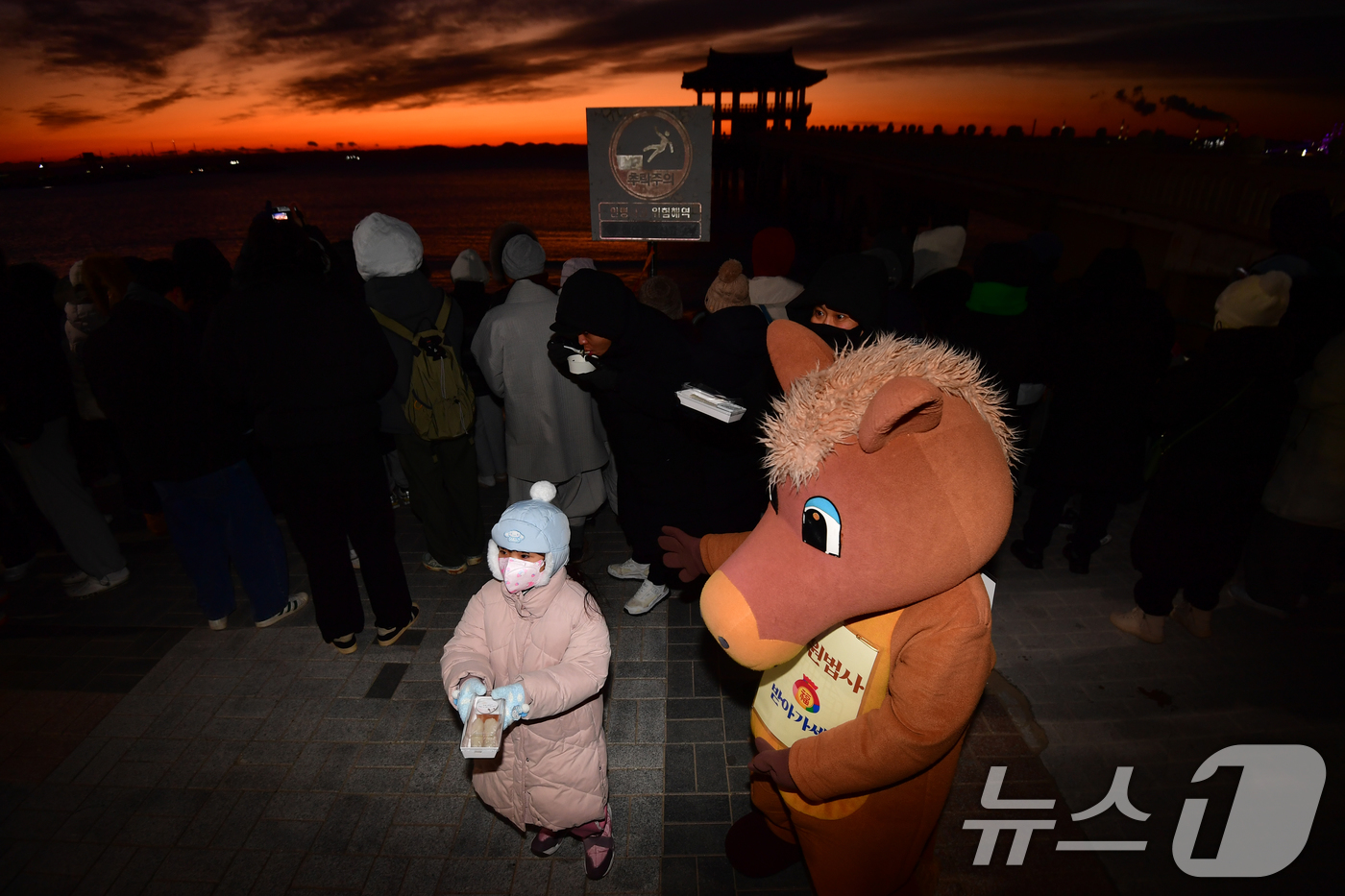 (포항=뉴스1) 최창호 기자 = 2026년 병오년 새해 첫 날인  1일 경북 포항시 영일대해수욕장 해상누각 앞에서 적토마 인형 옷을 입은 포항불교사암연합회원이 어린이들에게 가래떡을 …