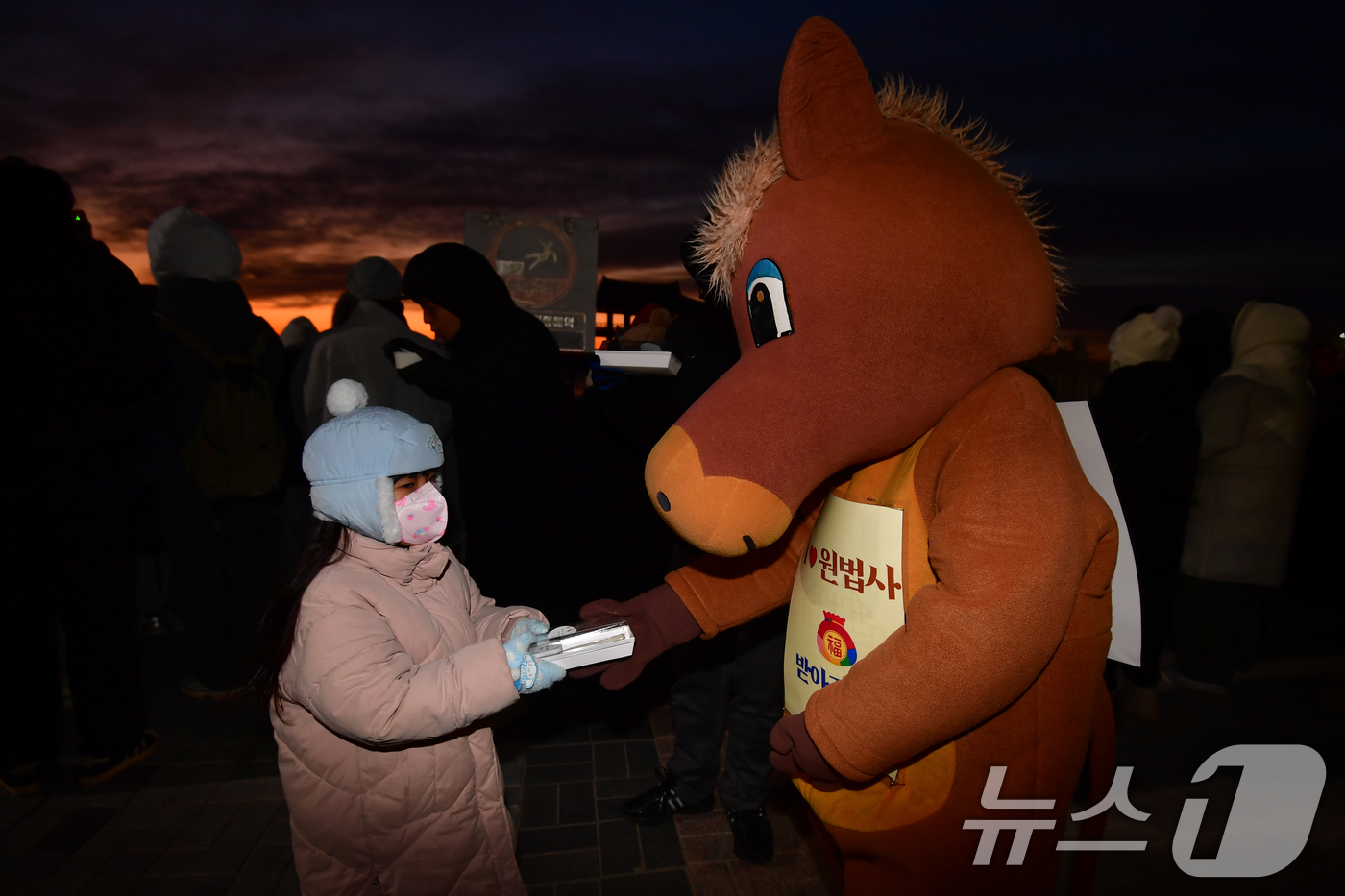 (포항=뉴스1) 최창호 기자 = 2026년 병오년 새해 첫 날인  1일 경북 포항시 영일대해수욕장 해상누각 앞에서 적토마 인형 옷을 입은 포항불교사암연합회원이 어린이들에게 가래떡을 …