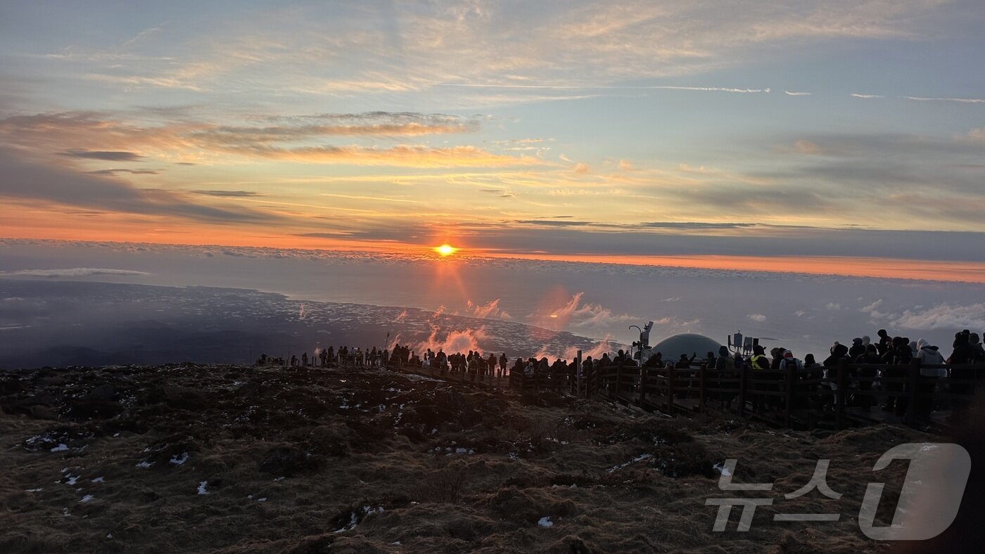 본문 이미지 - 2026년 새해 첫날인 1일 제주 한라산 정상인 백록담에 오른 탐방객들이 구름 사이로 뜨는 해를 바라보고 있다.(한라산국립공원관리소 제공. 재판매 및 DB 금지). 2026.1.1/뉴스1 ⓒ News1 강승남 기자