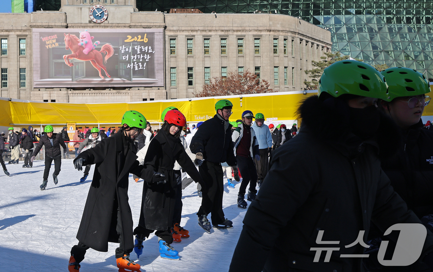 (서울=뉴스1) 오대일 기자 = 새해 첫 날인 1일 오후 서울 중구 서울광장 스케이트장을 찾은 시민들이 병오년(丙午年) '붉은 말'의 역동적인 이미지를 담은 서울도서관 외벽 신년편 …