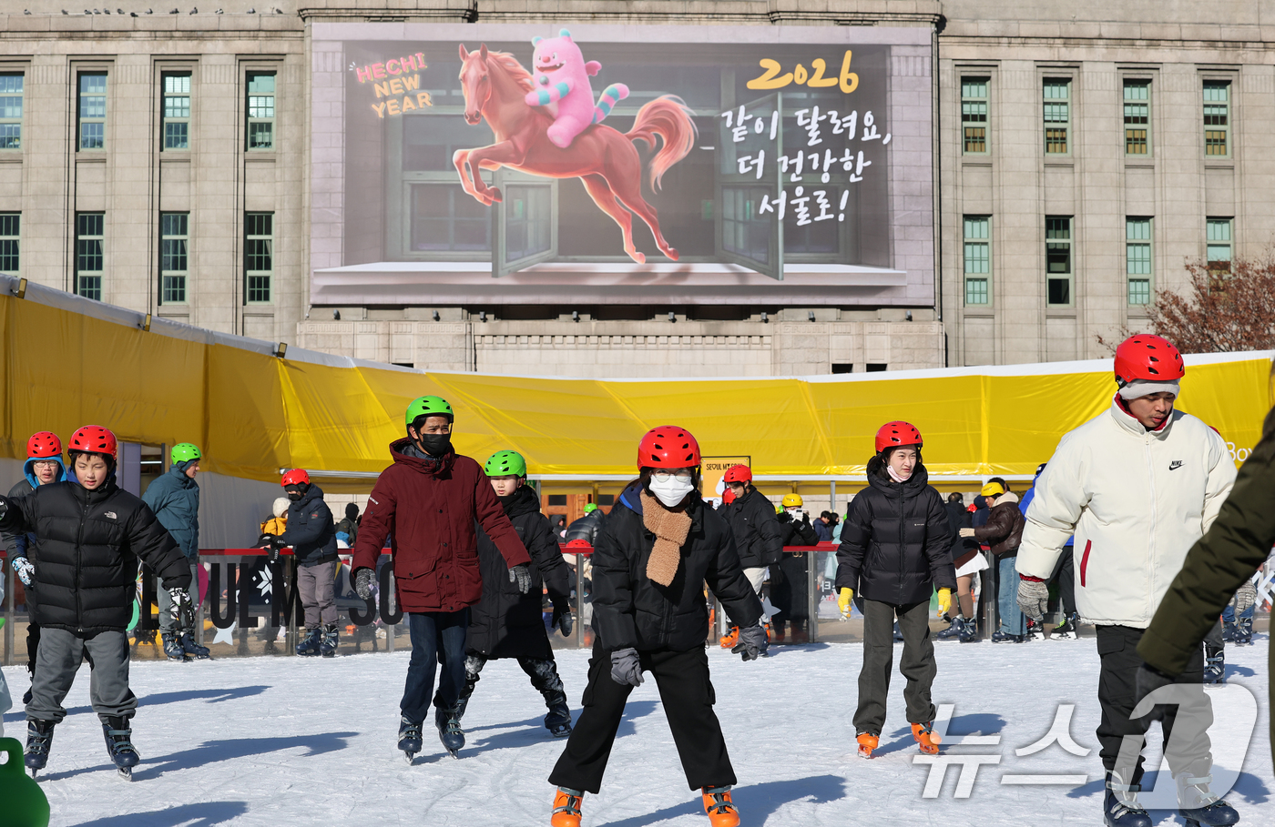 (서울=뉴스1) 오대일 기자 = 새해 첫 날인 1일 오후 서울 중구 서울광장 스케이트장을 찾은 시민들이 병오년(丙午年) '붉은 말'의 역동적인 이미지를 담은 서울도서관 외벽 신년편 …