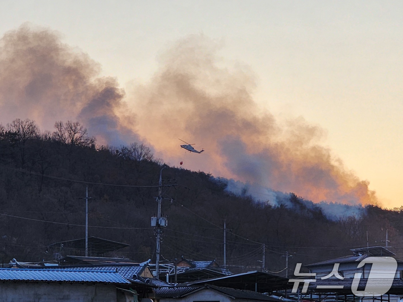 (의성=뉴스1) 신성훈 기자 = 11일 오전 7시 30분 일출과 함께 헬기를 투입해 경북 의성군 의성읍 비봉리에서 발생한 산불의 잔불을 진화하고 있다.  (경북소방본부 제공. 재판 …