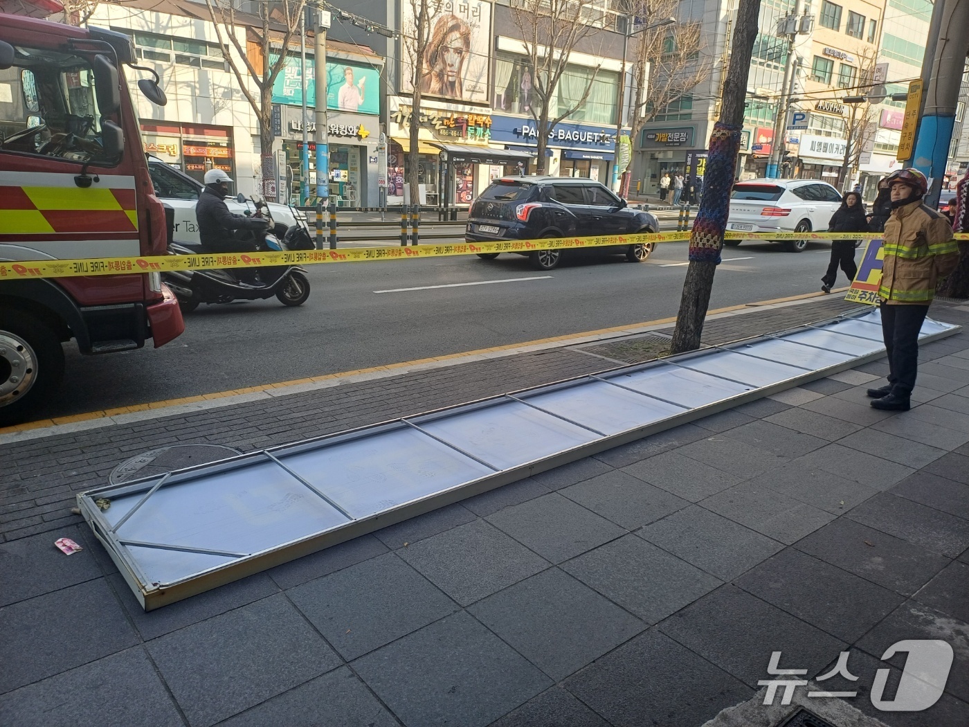 (서울=뉴스1) = 10일 오전 10시 21분쯤 중구 대청동에서 간판이 보행로로 떨어져 소방 관계자들이 안전 조치를 하고 있다.(부산소방재난본부 제공. 재판매 및 DB금지)