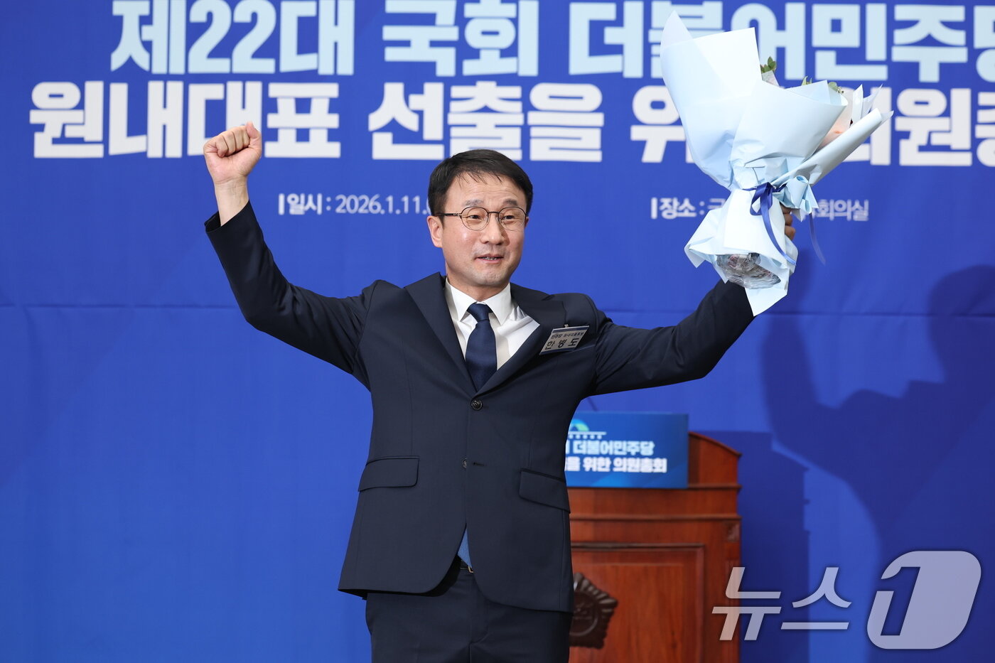 본문 이미지 - 더불어민주당 신임 원내대표로 선출된 한병도 의원이 11일 서울 여의도 국회에서 열린 제22대 국회 더불어민주당 원내대표 선출을 위한 의원총회에서 꽃다발을 들고 있다. 2026.1.11/뉴스1 ⓒ News1 유승관 기자